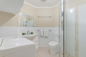 Een badkamer met een witte wastafel, spiegel en toilet.