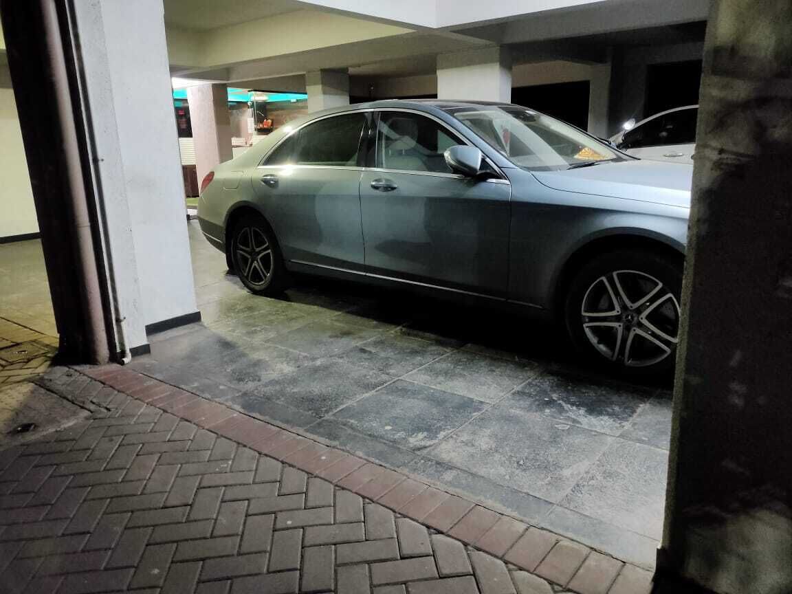 Um parque de estacionamento com um carro estacionado.