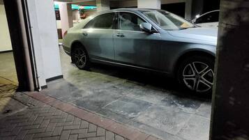 Um parque de estacionamento com um carro estacionado.