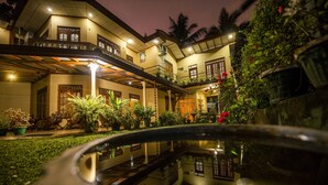 A multi-story building with a reflective pool in the foreground. - Wildlife Safari House (Udawalawa)