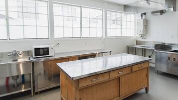 Una cocina moderna con electrodomésticos de acero inoxidable, una isla de madera y ventanas grandes.