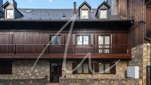 Ein zweistöckiges Holzhaus mit Steinmauern und einem Balkon.