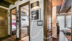 Ein Hotelzimmer mit Holzboden, einem Bett, einem Schreibtisch und einem Fenster mit Vorhängen.