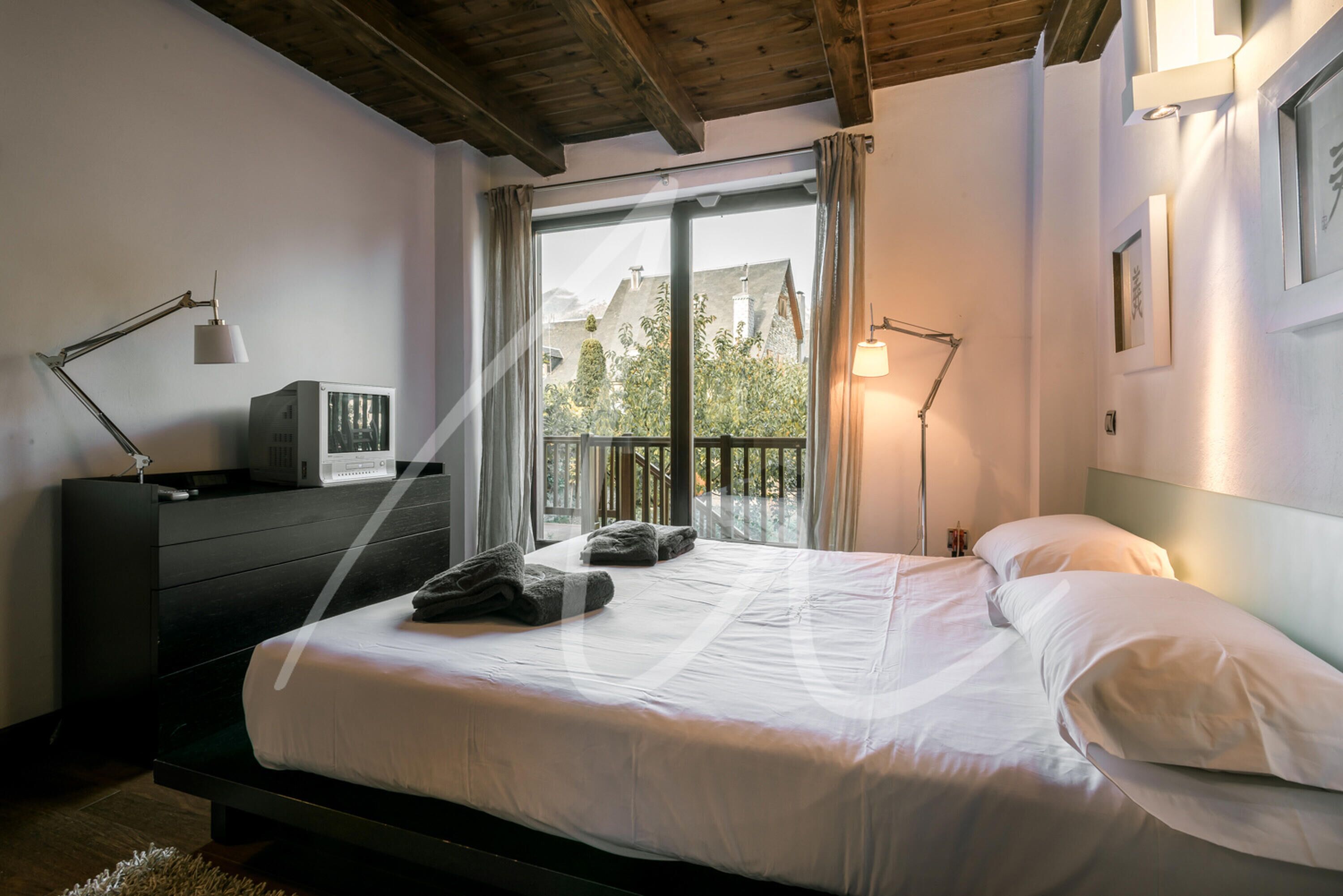 Un dormitorio con cama, cómoda, escritorio con computadora y ventana con cortinas.