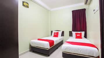 Habitación de hotel con dos camas, cada una con ropa de cama blanca y detalles en rojo, una cortina roja y un aire acondicionado de pared.