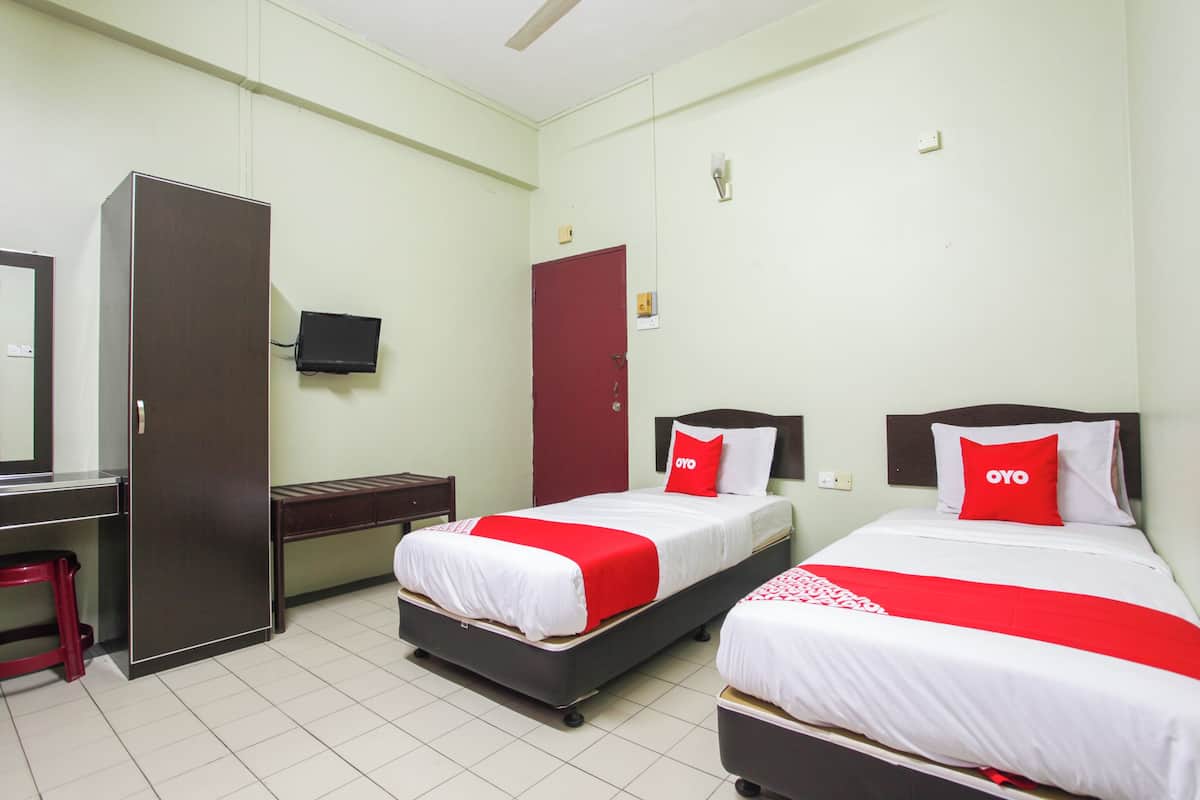 Une chambre d’hôtel avec deux lits, un bureau, une armoire et une télévision.