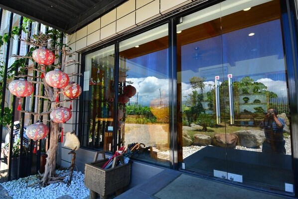A modern building with large glass windows reflecting a landscape.