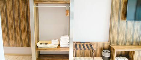 A bathroom with a wooden vanity, a towel rack, and a trash bin.