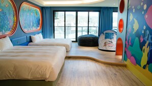Ein Hotelzimmer mit zwei Betten, einem Mickey-Mouse-Zelt, großen Fenstern und farbenfroher Wandgestaltung.