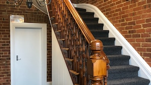 A staircase with wooden balusters and a carpeted landing. - Top floor 3 bed apartment in the iconic Tiger Tea Building ( FREE Netflix) (Dunedin)