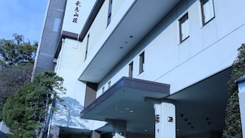 A modern building with a flat roof and a covered entrance area.