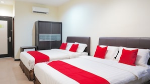Ein Hotelzimmer mit zwei Betten, jeweils mit weißer Bettwäsche und roten Akzenten, einem dunkelbraunen Kleiderschrank und einer Klimaanlage an der Wand.