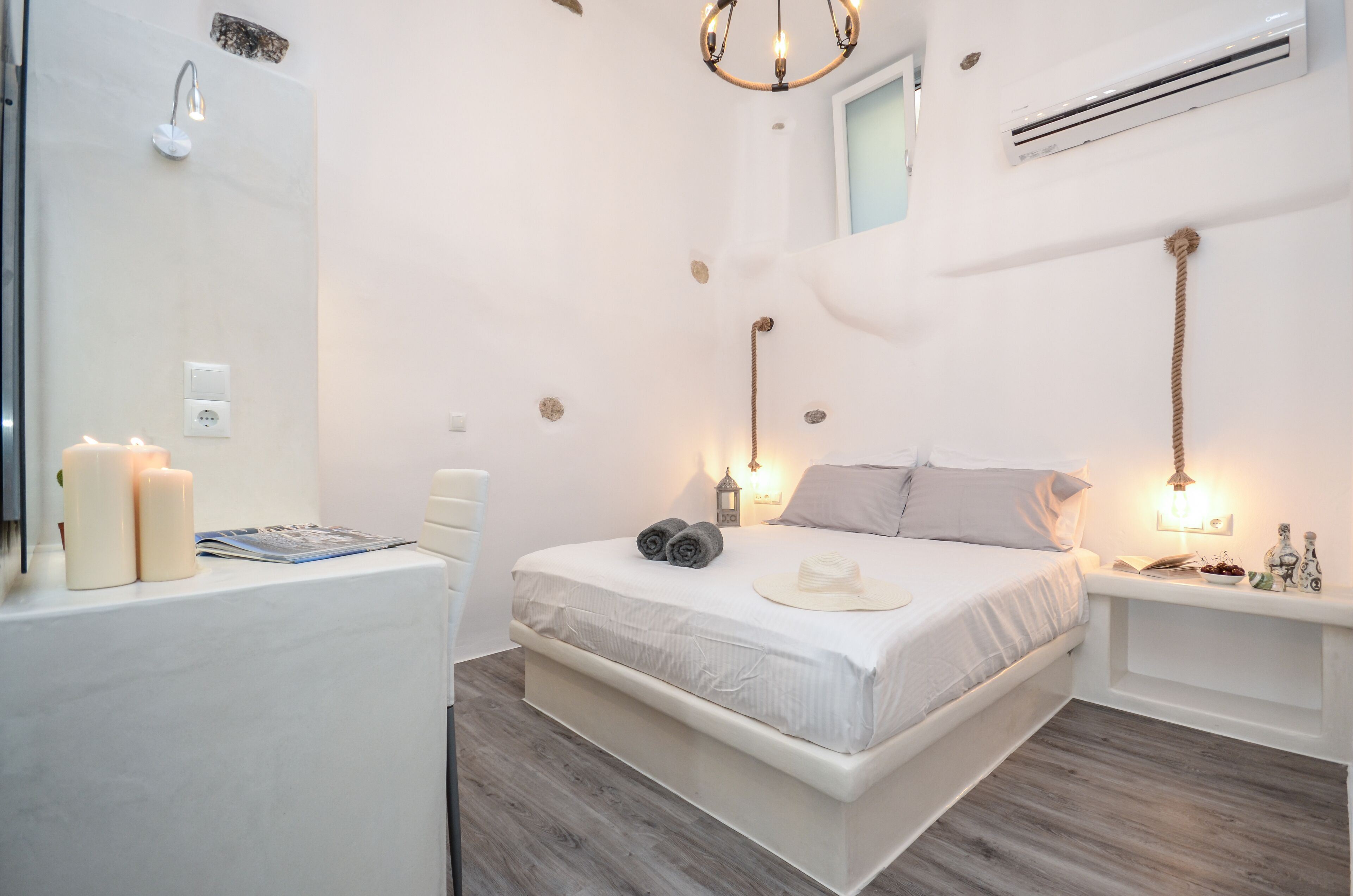 Un dormitorio con cama, lámparas de noche, mesita de noche y espejo.
