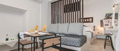 Ein modernes Wohnzimmer mit einer Couch, einem Esstisch und einem an einer Holzwand befestigten Fernseher.