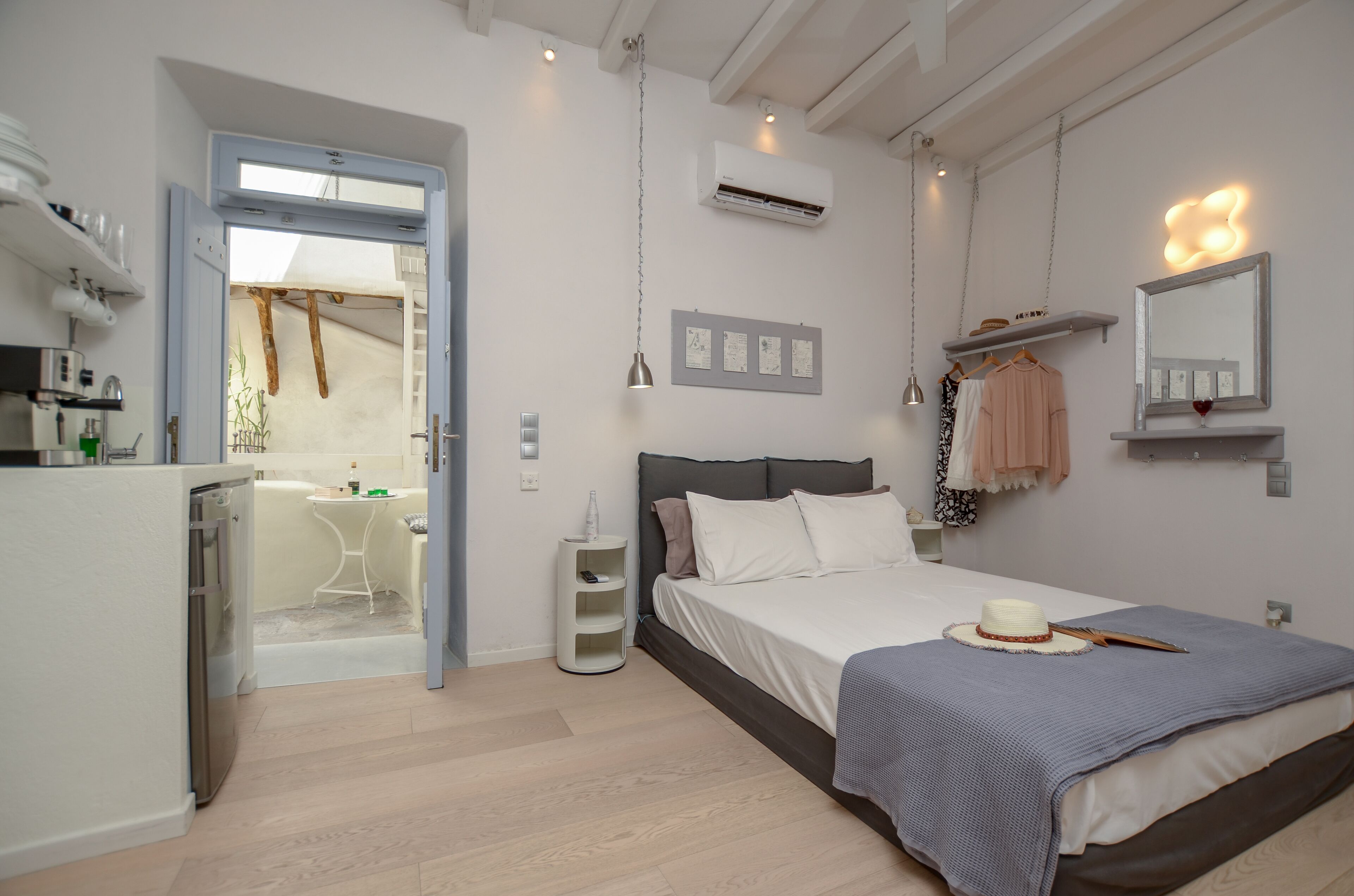 A bedroom with a bed, bedside table, and a small desk area with a chair.