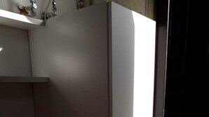 A kitchen with a white refrigerator, a washing machine, and a sink.