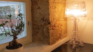Un arco in pietra che dà accesso a una stanza con una pianta in vaso e una lampada da tavolo.
