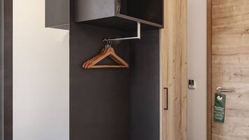 A compact room with a built-in wardrobe, a coat rack, and a door with a wooden finish.