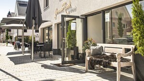 A modern building with a sign reading "GenussRaich byhotel". - Drexels Parkhotel am Schloss (Krumbach)