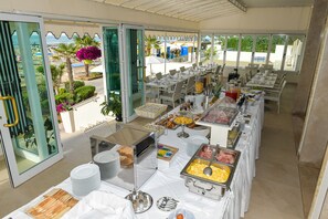 A buffet setup with various food stations, including fruits, meats, and baked goods. - Hotel Souvenir (Jesolo)
