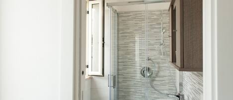 Un baño con cabina de ducha de vidrio, un lavabo y un armario de madera.
