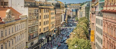 A street view of a city with historic buildings, a busy street, and a clear sky.