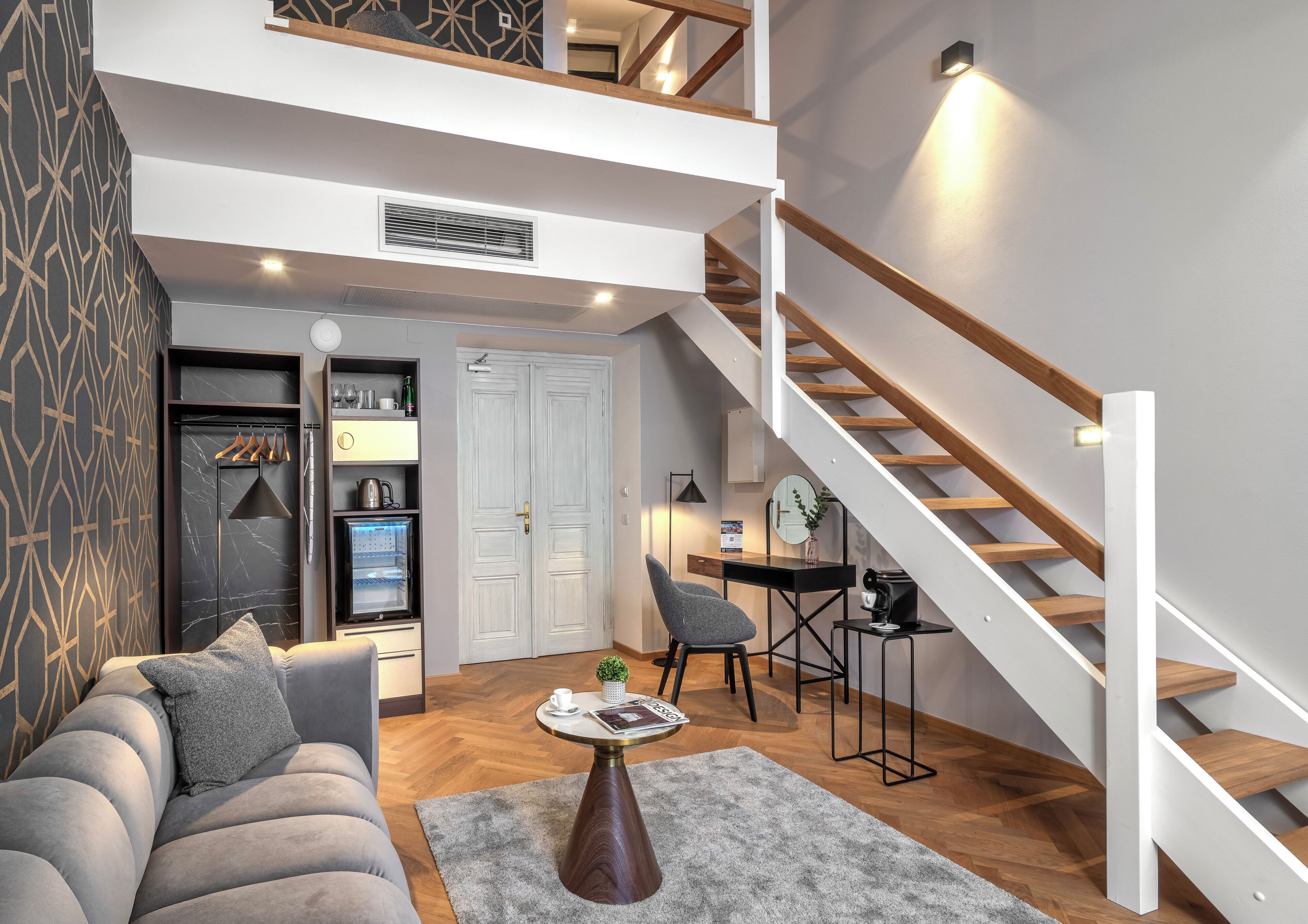 A modern living room with a sofa, coffee table, and a staircase.