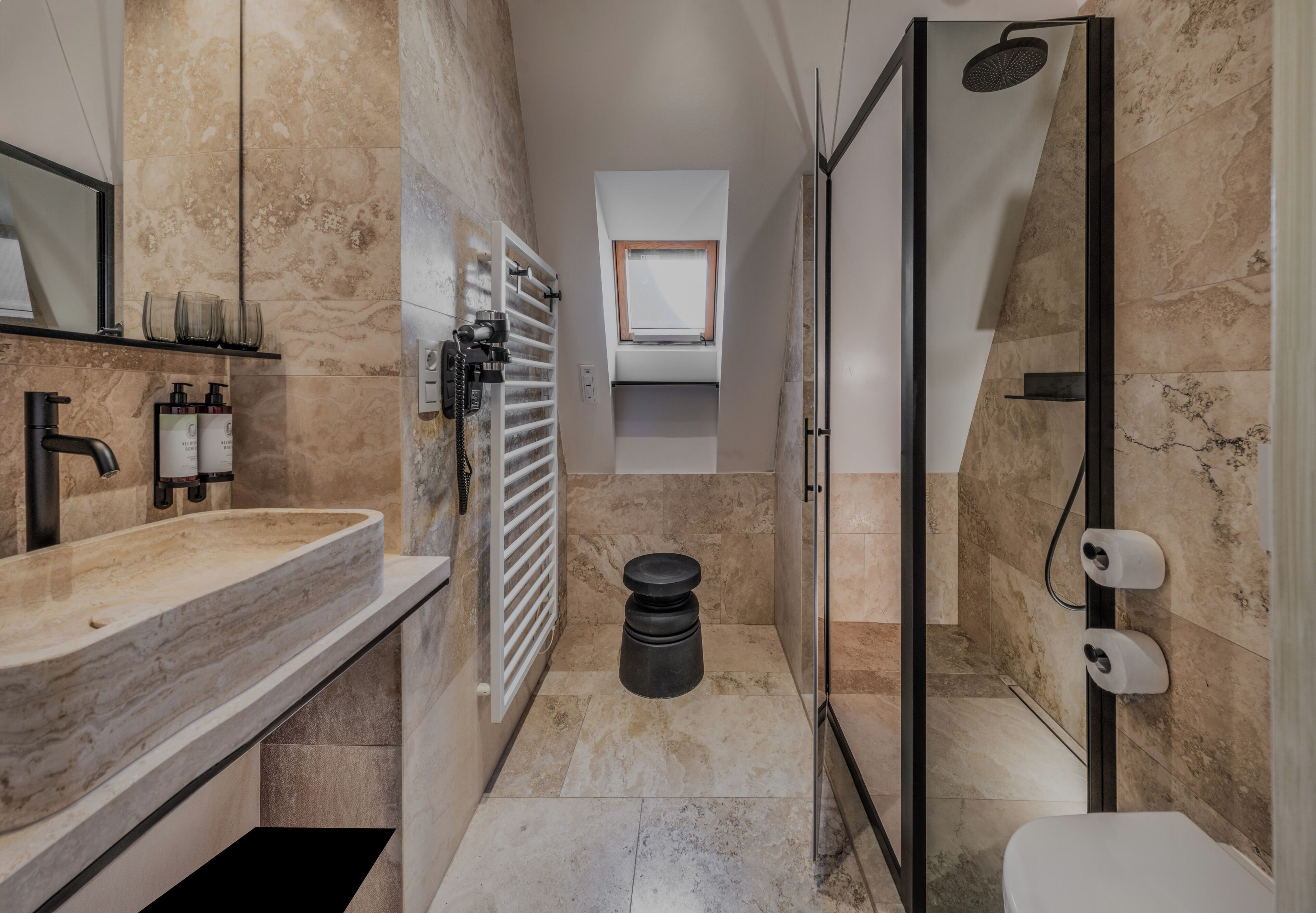 Une salle de bain moderne avec un lavabo en marbre, une douche et des toilettes.