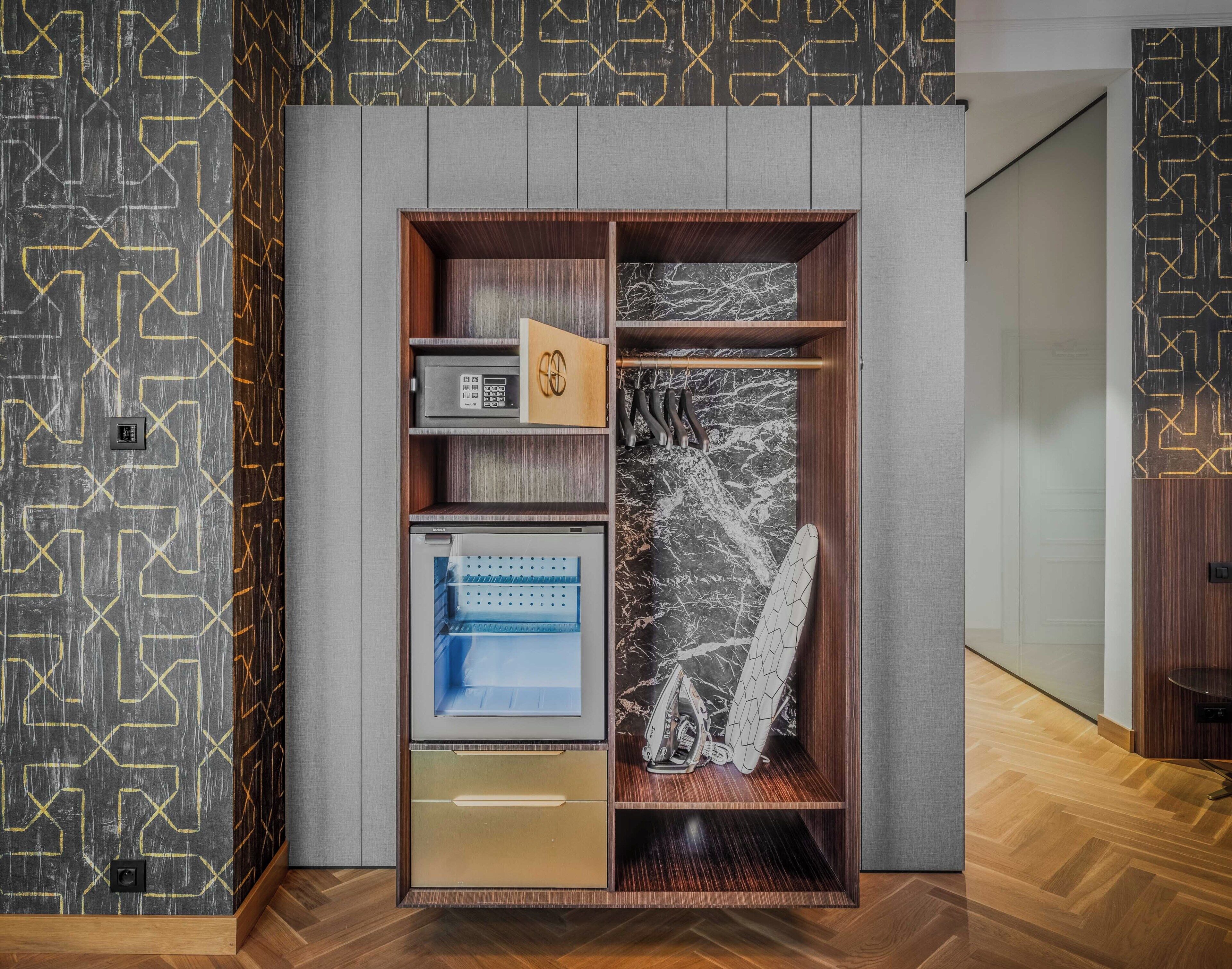 Un depósito moderno con refrigerador integrado, microondas y un perchero.