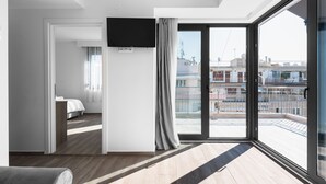 A modern hotel room with a large window, a flat-screen TV, and a bed. - Penthouse Level 8 Nilie Hospitality MGMT (Thessaloniki)
