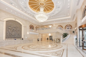 A grand lobby with a large chandelier, a central fountain, and a staircase leading to an upper level. - Vienna International Hotel - Ningbo City West Xintiandi (Ningbo)