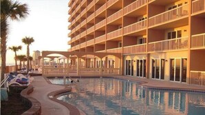 Un hôtel doté d’une piscine, de nombreux balcons et de palmiers.
