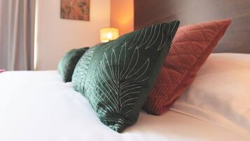 A bed with two pillows, one green and one brown, in a hotel room.