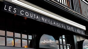 The exterior of Les Coutainvillaises Café & Hotel with a sign above the entrance.