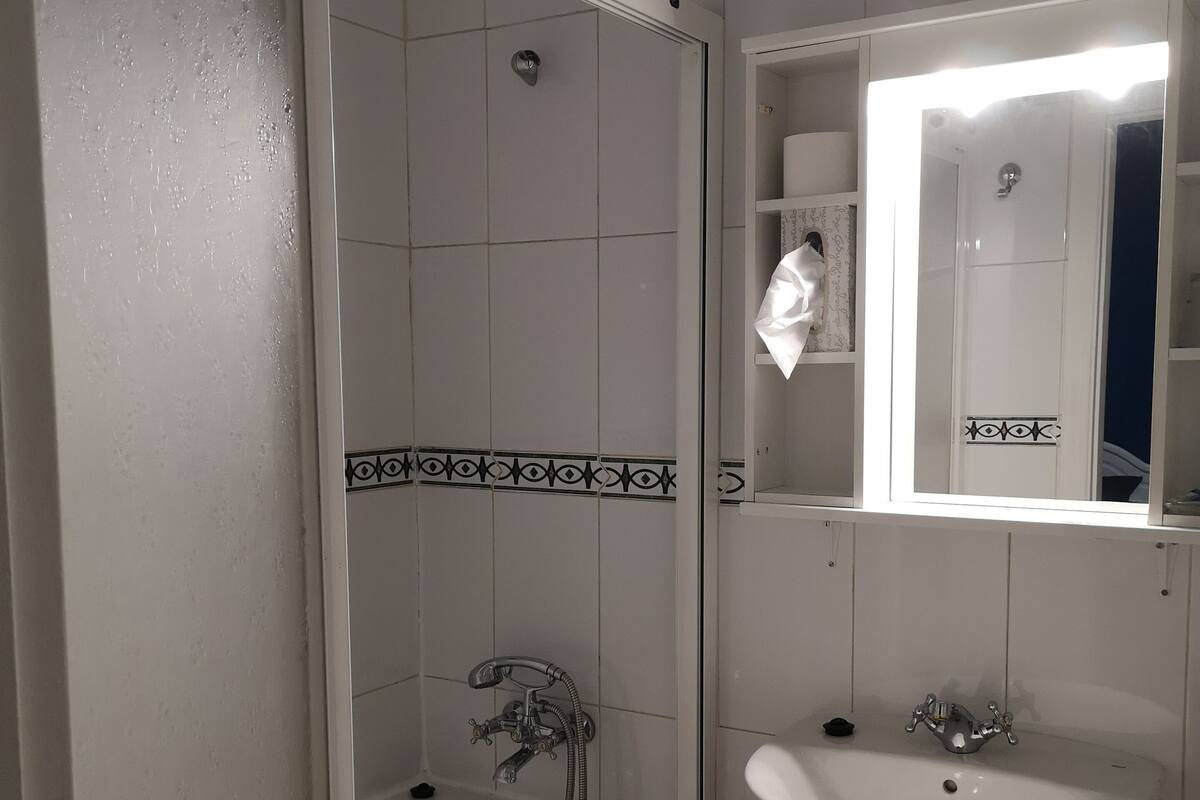 A bathroom with a bathtub, a sink, and a mirror.