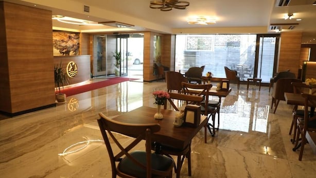A hotel lobby with a reception desk, seating area, and large windows. - Radar Otel (Istanbul)