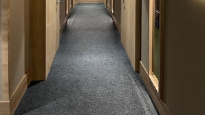 A hallway with wooden paneling, a carpeted floor, and a sign indicating room numbers 301 and 307. - Radar Otel (Istanbul)