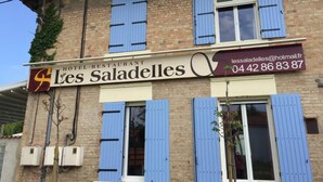 Ein Hotel namens „Les Saladelles“ mit einem Schild, das den Namen und die Kontaktdaten anzeigt.