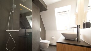 A modern bathroom with a glass-enclosed shower, a white toilet, and a large sink with a vessel basin. - Rent A Place 4, Copenhagen (København)