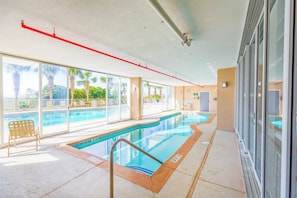 A swimming pool area with clear views of palm trees and a building exterior.