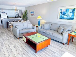 A living room with a sofa set, a coffee table, and a dining area with chairs.
