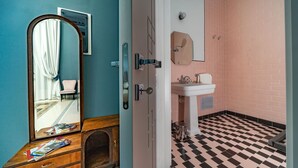 Un baño con piso a cuadros, un lavamanos y un espejo.