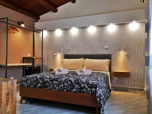 A neatly arranged bedroom with a bed, bedside lamps, and a wall-mounted light fixture. - Bed and Breakfast L&P (Cefalù)