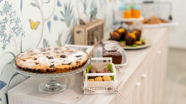 A buffet table with a variety of desserts including a pie, muffins, and pastries. - Il Tulipano Verde B&B (Putignano)