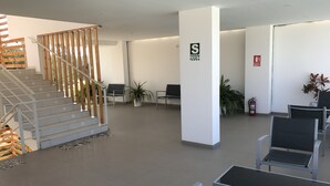 Un hall d’entrée spacieux avec un escalier, un coin salon et un extincteur.