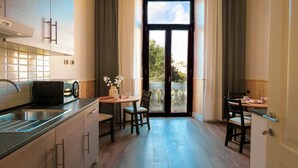 Uma cozinha moderna com forno embutido, pia e área de refeições com duas cadeiras e uma mesa.