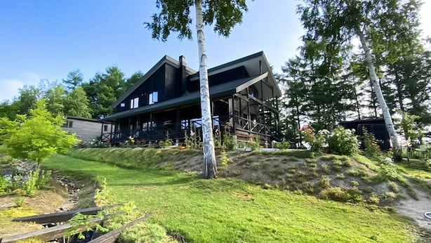 A two-story house with a large deck and a staircase leading to the upper floor. - Ritz Garden Niji (Biei)