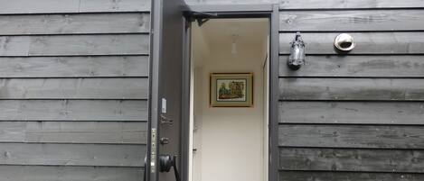 A wooden exterior with a door leading to an interior space.