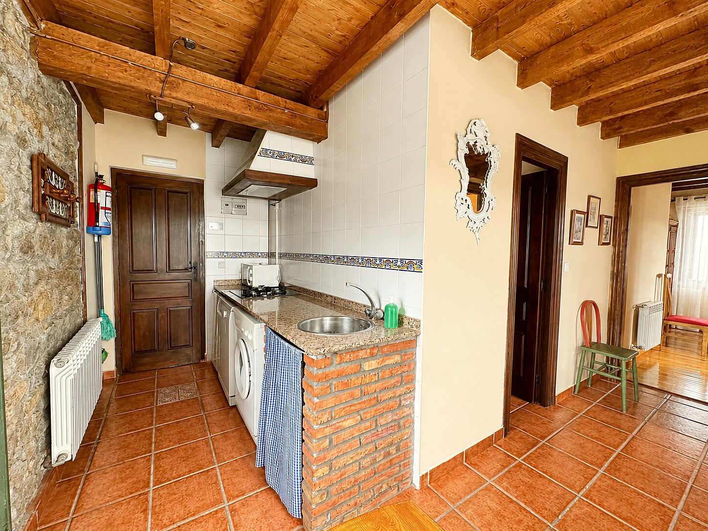 Una cocina con una isla de ladrillo, lavadora y un radiador.