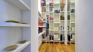 A modern library with white shelves and a wooden floor. - San Lorenzo (Rome)